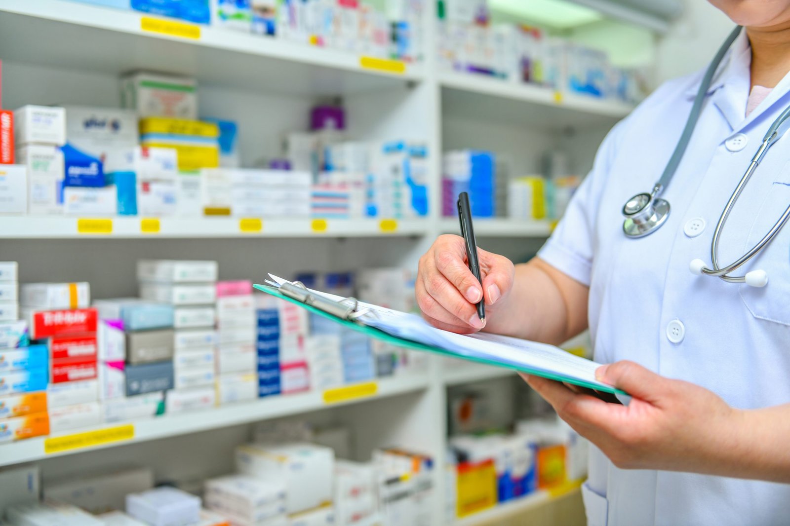 doctor-writing-prescription-with-many-medicine-shelves